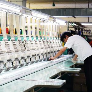 9-needle 24-head embroidery machine precisely stitching team logo, 1,200 stitches per minute